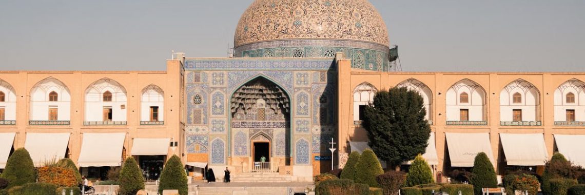 Beautiful view of Sheikh Lotfollah Mosque in Isfahan, Iran reflecting in a pond during the day.